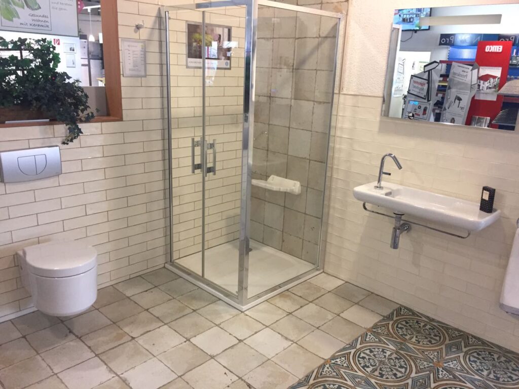 Showroom-Bad mit Duschkabine, Wand- und Bodenfliesen, WC und Waschbecken; Beispiel für Badsanierung und Fliesenarbeiten